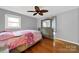 Bedroom with hardwood floors, a ceiling fan and neutral paint, containing a dresser at 7410 Middlebury Pl, Charlotte, NC 28212
