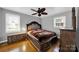 Bedroom with hardwood floors, ceiling fan, neutral walls and an ornate wooden bed frame at 7410 Middlebury Pl, Charlotte, NC 28212