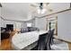 Bright dining area open to the living room, featuring hardwood floors and a ceiling fan at 7410 Middlebury Pl, Charlotte, NC 28212