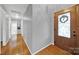 Inviting hallway features hardwood floors and a decorative front door with glass panes at 7410 Middlebury Pl, Charlotte, NC 28212