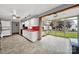 Open kitchen and sunroom featuring white cabinets, red counters, and great backyard views at 7410 Middlebury Pl, Charlotte, NC 28212
