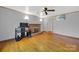 Spacious living room featuring a brick fireplace, ceiling fan, and hardwood floors at 7410 Middlebury Pl, Charlotte, NC 28212