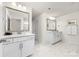 Bright bathroom with double sinks and vanities, mirrors, and marble-tiled floors at 8143 Warford Little Rd, Denver, NC 28037