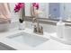 Close up of a bathroom sink with running water, potted plant, soap, and a pink towel at 8143 Warford Little Rd, Denver, NC 28037