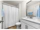 Well-lit bathroom featuring a vanity with modern fixtures and a shower with a white curtain at 8143 Warford Little Rd, Denver, NC 28037
