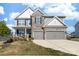 Charming two-story home featuring a stone facade, gray siding, covered porch, and a two-car garage at 8143 Warford Little Rd, Denver, NC 28037
