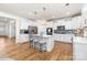 Bright and spacious kitchen with white cabinetry, stainless steel appliances, island with seating, and hardwood floors at 8143 Warford Little Rd, Denver, NC 28037