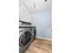 Modern laundry room with stainless steel appliances, white cabinets, and wood-look flooring at 8143 Warford Little Rd, Denver, NC 28037