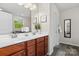 Bathroom boasts double sinks with cherry wood cabinets, white countertops, and decorative plants at 9618 Springholm Dr, Charlotte, NC 28278