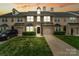 Charming townhouse showcasing a stone facade, two-car garage, and well-manicured lawn at sunset at 9618 Springholm Dr, Charlotte, NC 28278