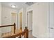 Bright hallway features neutral walls, carpeted floors, wooden banister and multiple doorways that enhances the home's appeal at 9618 Springholm Dr, Charlotte, NC 28278
