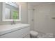 Bright bathroom featuring a white vanity, subway tile shower, and a window at 10805 Winterbourne Ct, Charlotte, NC 28277
