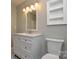 Bathroom features a white vanity, toilet, modern vanity lighting, and decorative mirror at 10805 Winterbourne Ct, Charlotte, NC 28277