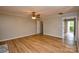 Spacious living room with wood floors, ceiling fan, and access to the outdoors at 10805 Winterbourne Ct, Charlotte, NC 28277