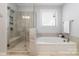This bathroom features a separate tub and shower, white cabinets, and neutral tile at 109 Crossvine Dr, Mooresville, NC 28117