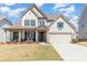 Charming two-story home features a well-manicured lawn, inviting front porch, and attached two car garage at 109 Crossvine Dr, Mooresville, NC 28117