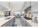 Bright kitchen with an island, gray cabinets, and stainless steel appliances, seamlessly connecting to the dining area at 109 Crossvine Dr, Mooresville, NC 28117