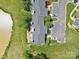 Aerial view of townhome rooftops and parking near pond and green common area at 10942 Winterbourne Ct, Charlotte, NC 28277