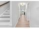 Bright hallway with hardwood floors, white walls, leading to living area and stairs at 10942 Winterbourne Ct, Charlotte, NC 28277