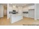 Modern, all-white kitchen with a large center island, stainless steel appliances, and light hardwood floors at 1107 Meander Ln, Waxhaw, NC 28173
