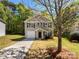 Charming two-story house with gray siding, a driveway, and a one-car garage at 1107 Stonehenge Ln, Charlotte, NC 28216