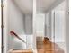 Hallway with hardwood floors, stairs, and white doors at 1107 Stonehenge Ln, Charlotte, NC 28216