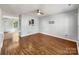 Bright living room with hardwood floors, a ceiling fan, and a pass-through window to the kitchen at 1107 Stonehenge Ln, Charlotte, NC 28216