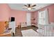 Cozy bedroom with pink walls, ceiling fan, white trim, wood floors and white shag rug at 126 Newsome Rd, Salisbury, NC 28146