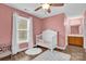 Bright, comfortable bedroom with white crib, ceiling fan, and ensuite bathroom at 126 Newsome Rd, Salisbury, NC 28146
