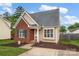 Charming single-story home featuring a brick facade, manicured lawn, and inviting front porch at 126 Newsome Rd, Salisbury, NC 28146