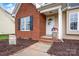 Inviting front entrance with brick accents, a white door, and meticulously maintained landscaping at 126 Newsome Rd, Salisbury, NC 28146