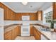 Functional kitchen with wooden cabinets, white appliances, and a window providing natural light at 126 Newsome Rd, Salisbury, NC 28146
