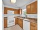 Functional kitchen with wooden cabinets, white appliances, and a window providing natural light at 126 Newsome Rd, Salisbury, NC 28146