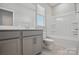 Well-lit bathroom with a gray vanity, white countertop, and a combined tub and shower unit at 134 Berkeley Ave, Mooresville, NC 28117