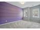 Bedroom showcasing a purple accent wall, plush gray carpet, and abundant natural light through two windows at 134 Berkeley Ave, Mooresville, NC 28117