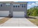 Exterior view of a home with a gray facade, a driveway leading to a garage and landscaping at 134 Berkeley Ave, Mooresville, NC 28117