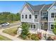 An aerial view of a gray two-story townhome featuring a landscaped front yard with white railing and healthy lawn at 134 Berkeley Ave, Mooresville, NC 28117