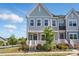 Charming two-story townhome with a landscaped front yard and inviting entrance with white railing at 134 Berkeley Ave, Mooresville, NC 28117