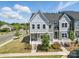 Charming two-story gray townhome with a landscaped front yard and inviting entrance on a sunny day at 134 Berkeley Ave, Mooresville, NC 28117