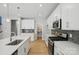 Modern kitchen with white cabinets, stainless appliances, stylish backsplash, and spacious island at 134 Berkeley Ave, Mooresville, NC 28117