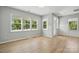 Bright, neutral living space features wood flooring and large windows offering ample natural light at 134 Berkeley Ave, Mooresville, NC 28117