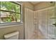 This bathroom features a white shower stall and a window with a view of the backyard at 139 Sanford Ln, Badin Lake, NC 28127