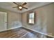 This bedroom features light, neutral-colored walls, wood-look floors, and a window with a view at 139 Sanford Ln, Badin Lake, NC 28127