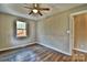 This bedroom features light, neutral-colored walls, wood-look floors, and a window with a view of trees at 139 Sanford Ln, Badin Lake, NC 28127
