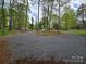 Gravel driveway with mature trees offering privacy and leading to the home at 139 Sanford Ln, Badin Lake, NC 28127