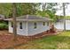 Charming exterior view of gray home with white trim with lake and wooded views at 139 Sanford Ln, Badin Lake, NC 28127