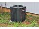 Goodman HVAC unit sitting on a bed of pine needles in a yard at 139 Sanford Ln, Badin Lake, NC 28127