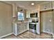 Modern kitchen with stainless steel appliances, white cabinets, and wood-look flooring at 139 Sanford Ln, Badin Lake, NC 28127