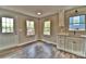 Bright kitchenette featuring white cabinets, wood-look floors, and lake views from the window at 139 Sanford Ln, Badin Lake, NC 28127