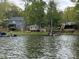 Scenic lakefront property with a blue house and private dock at 139 Sanford Ln, Badin Lake, NC 28127